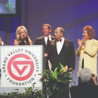 The DeVos family with Donna and Jim Brooks, along with President Emeritus Tom Haas standing on stage.